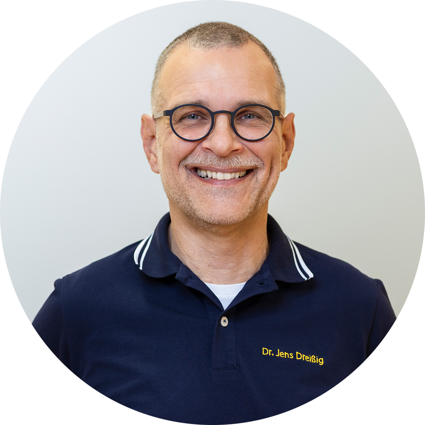 Dr. Jens Dreißig, lächelnder Mann mit Brille im dunkelblauen Polo-Shirt